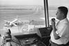 A Federal Aviation Agency (FAA) Air Traffic Controller guides a plane to a safe landing, 1965.