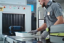 Airport,Security,Checkpoint:,Security,Officer,Putting,Suitcases,And,Personal,Items