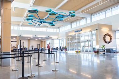 Columbia Regional Airport terminal interior with modern design, check-in area, passengers and contemporary ceiling installation enhancing passenger experience