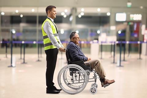 Assitance,Worker,Helping,A,Male,Passenger,In,A,Wheelchair,At