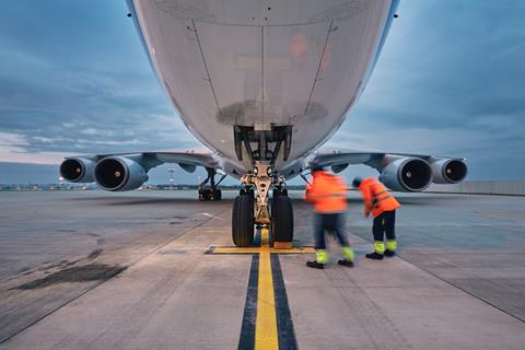 Low,Angle,View,Of,Freight,Airplane.,Ground,Staff,At,Airport.