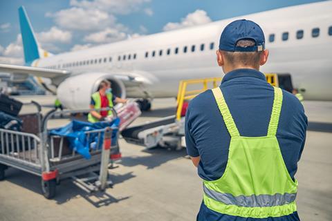Back,View,Of,An,Airport,Male,Worker,Controlling,The,Luggage