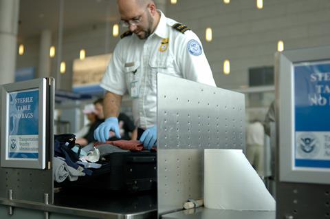 A,Tsa,Agent,Searches,Luggage,At,An,Airport.,(12mp,Camera,